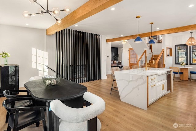 kitchen featuring white cabinets, decorative light fixtures, sink, and beamed ceiling