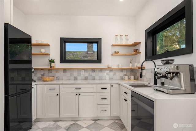 kitchen featuring a healthy amount of sunlight, black appliances, tasteful backsplash, white cabinetry, and sink