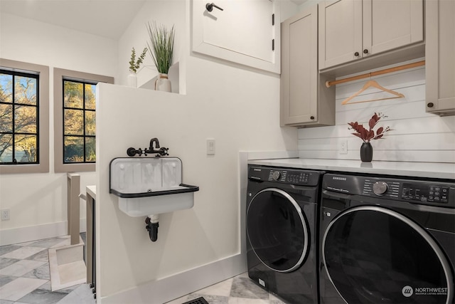 clothes washing area featuring sink, cabinets, and washing machine and clothes dryer