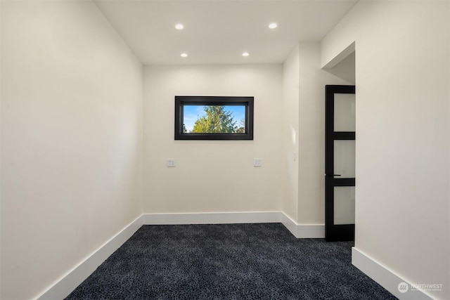 unfurnished room with dark carpet