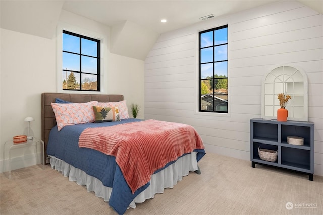 bedroom with vaulted ceiling, carpet, and multiple windows