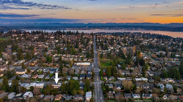 aerial view at dusk featuring a water view