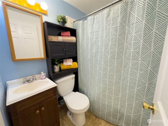 bathroom with tile patterned flooring, vanity, toilet, and walk in shower