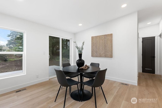 dining space with a wealth of natural light and light hardwood / wood-style flooring