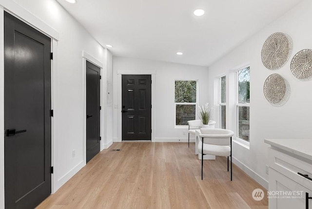 entrance foyer with light hardwood / wood-style floors and lofted ceiling