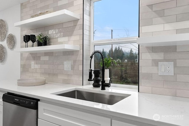 kitchen featuring dishwasher, backsplash, white cabinets, and sink