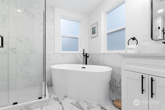 bathroom featuring shower with separate bathtub and tile walls