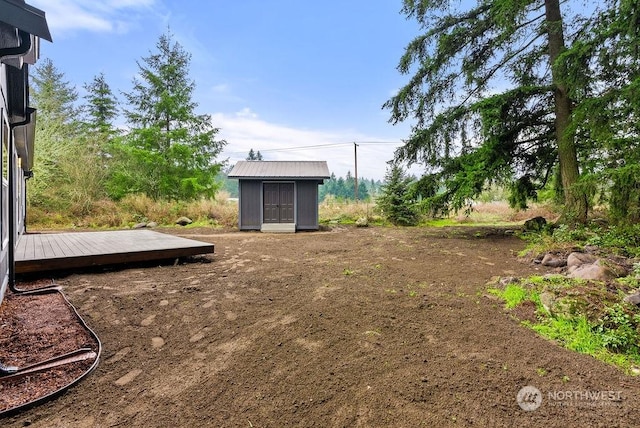 view of yard with a storage shed and a wooden deck