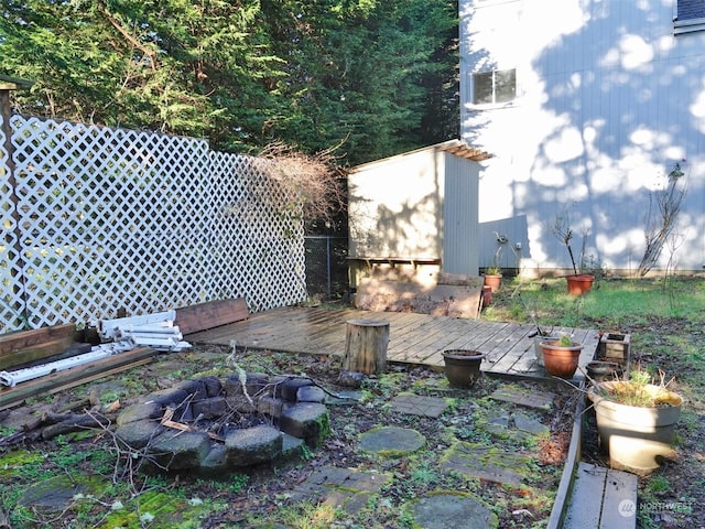 view of yard with an outdoor fire pit, a storage unit, and a wooden deck