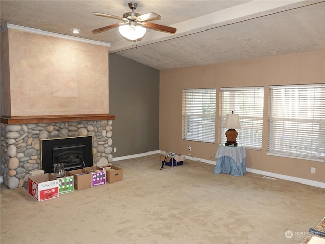 unfurnished living room with a stone fireplace, ceiling fan, carpet floors, vaulted ceiling with beams, and a textured ceiling