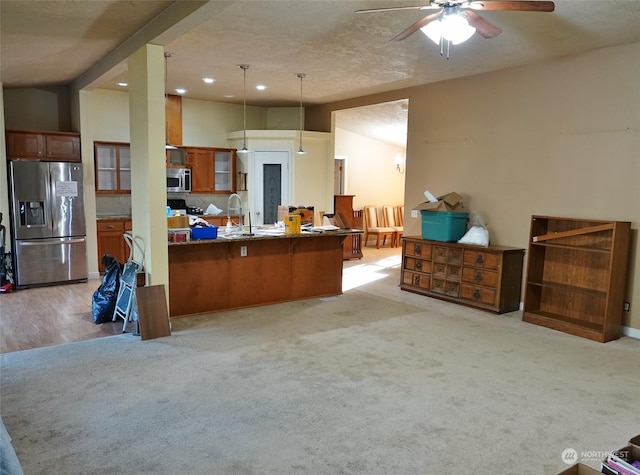 kitchen with kitchen peninsula, stainless steel appliances, backsplash, decorative light fixtures, and vaulted ceiling