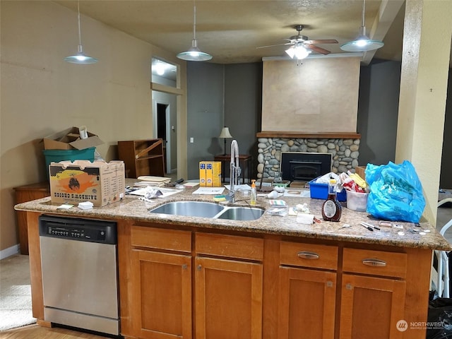 kitchen with stainless steel dishwasher, light stone counters, hanging light fixtures, and sink