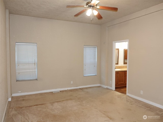 carpeted empty room featuring ceiling fan and a textured ceiling