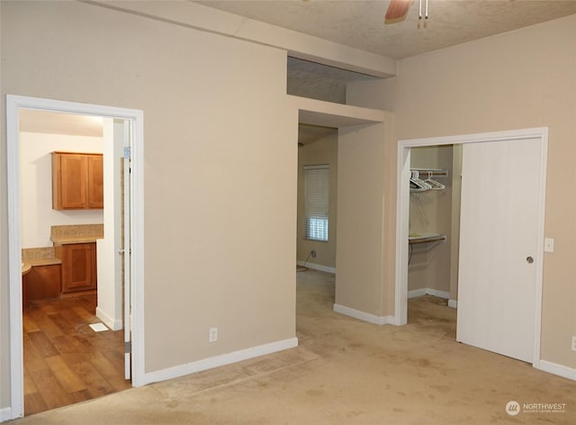 unfurnished bedroom with light carpet, a closet, and ceiling fan