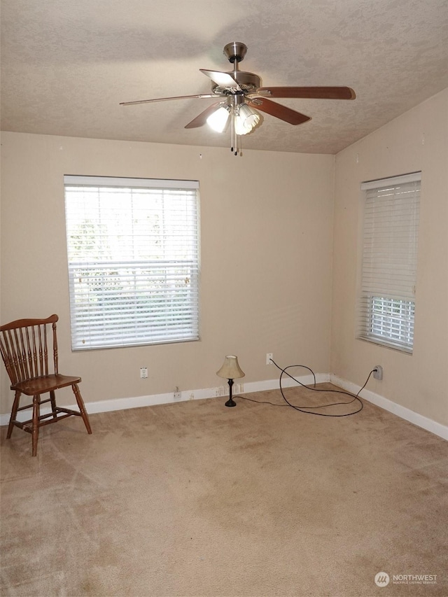 carpeted spare room with ceiling fan, vaulted ceiling, and a textured ceiling