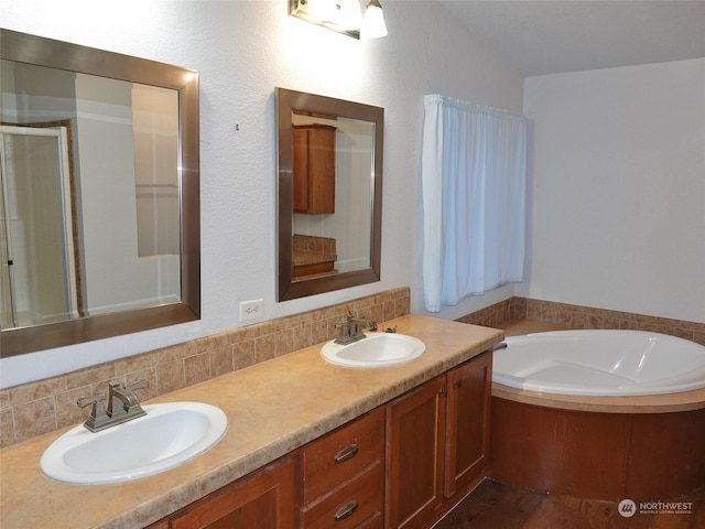 bathroom featuring a tub, backsplash, and vanity