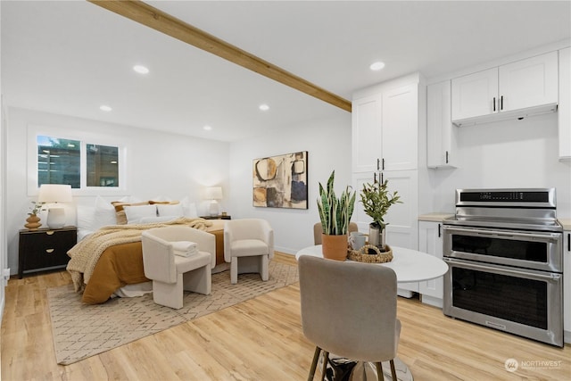 bedroom featuring light hardwood / wood-style floors and beam ceiling