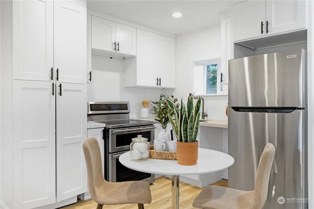 kitchen featuring white cabinets, stainless steel appliances, and light hardwood / wood-style floors