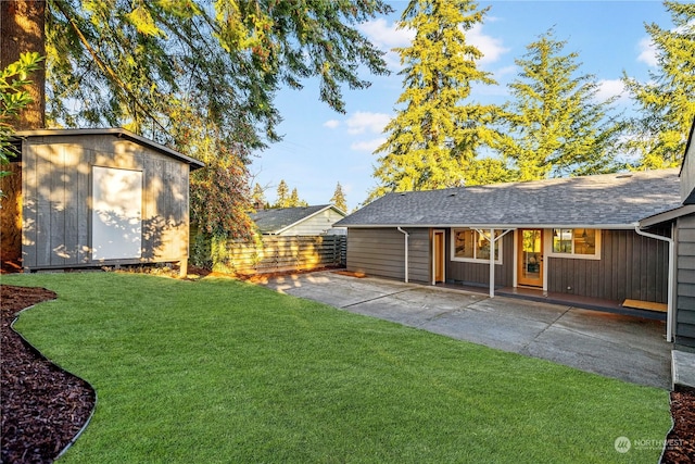 back of property with a patio area, a yard, and a shed