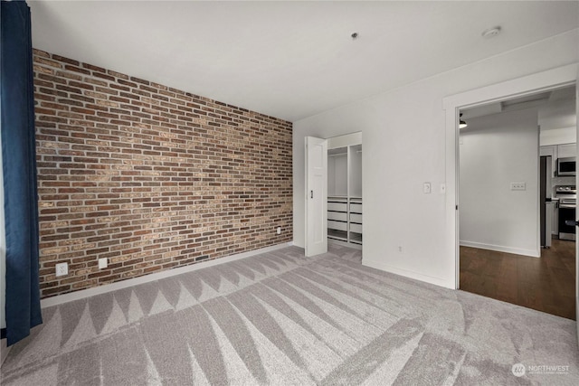 interior space featuring brick wall, a closet, and carpet