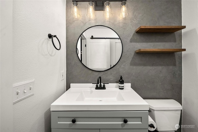 bathroom featuring toilet and vanity