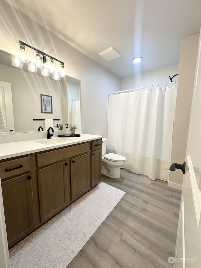 bathroom with hardwood / wood-style flooring, vanity, and toilet