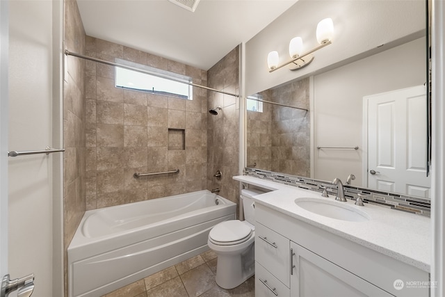 full bathroom with vanity, tiled shower / bath, tile patterned flooring, toilet, and tasteful backsplash