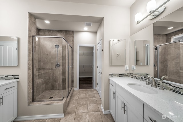 bathroom with tile patterned floors, vanity, and an enclosed shower