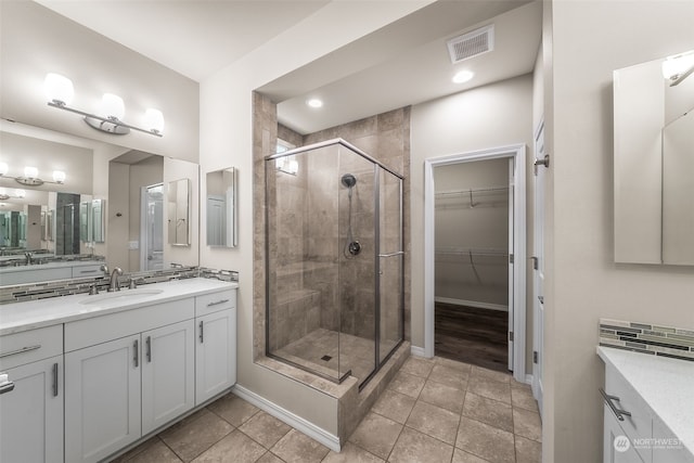 bathroom with tile patterned flooring, vanity, and an enclosed shower