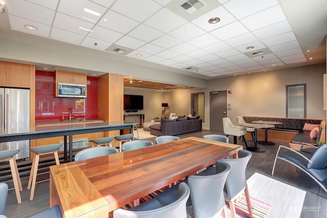 dining area with a paneled ceiling and sink