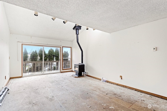 unfurnished living room featuring a wood stove and a textured ceiling