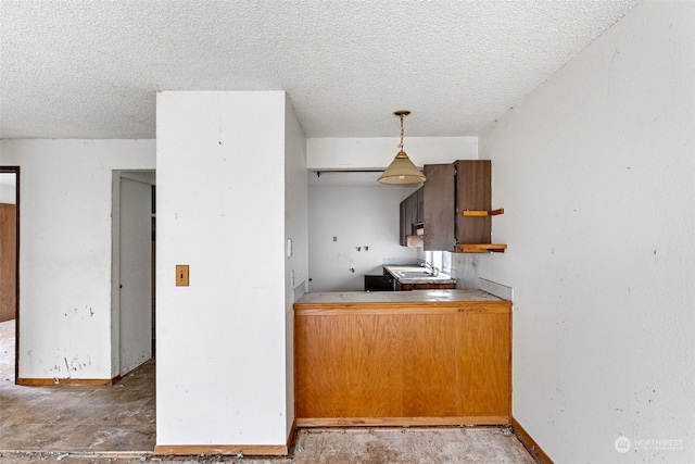 kitchen featuring sink, hanging light fixtures, and a textured ceiling