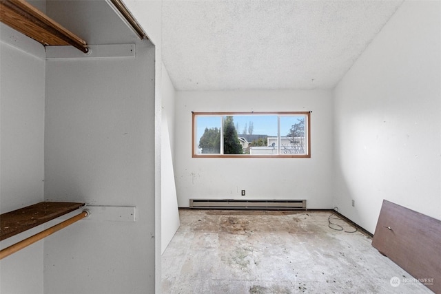 spare room featuring a textured ceiling and baseboard heating