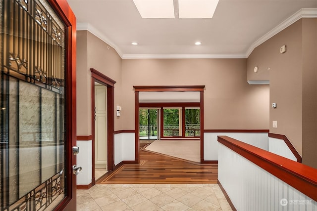 hall with light tile patterned floors and crown molding