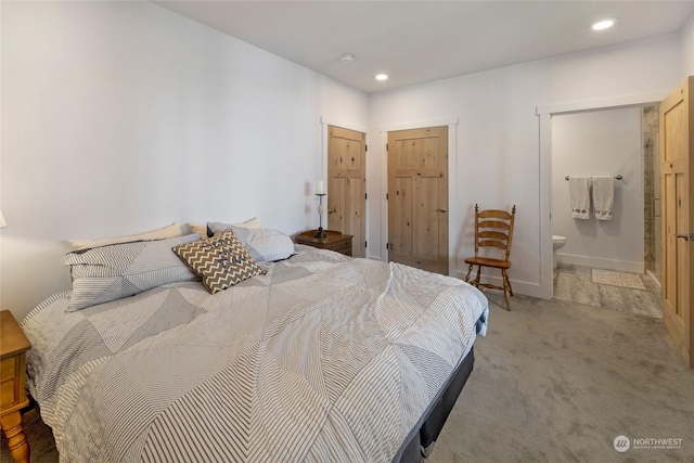 bedroom with ensuite bath and carpet floors