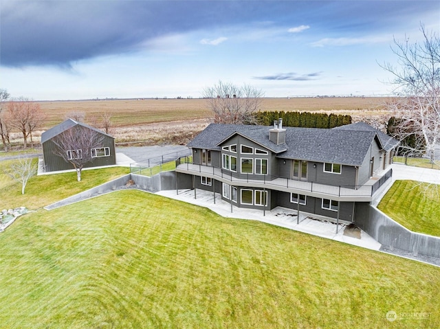 rear view of property with a yard and a rural view