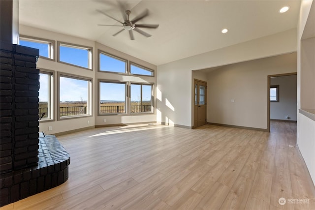 unfurnished living room with a fireplace, light hardwood / wood-style flooring, ceiling fan, and lofted ceiling