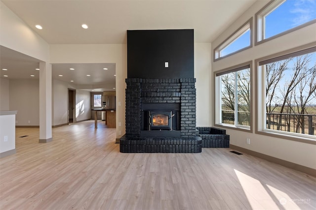 living room with light hardwood / wood-style flooring and a brick fireplace