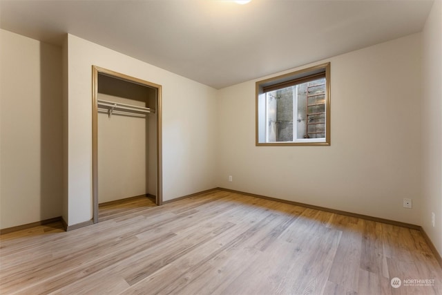 unfurnished bedroom featuring a closet and light wood-type flooring