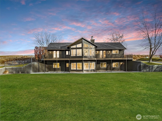 rear view of property featuring a chimney, a yard, and a patio area