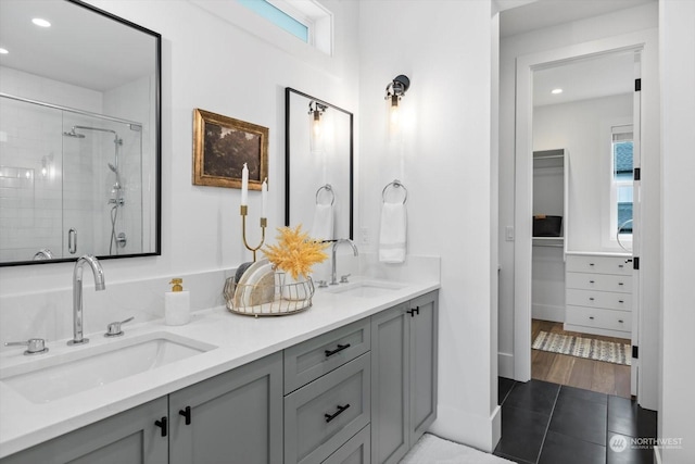 bathroom with tile patterned flooring, vanity, and walk in shower