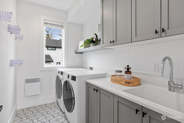 clothes washing area with cabinets, washer and dryer, and sink