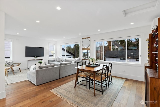 dining space with light hardwood / wood-style floors and a wall mounted air conditioner