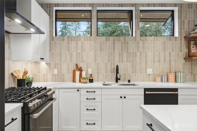 kitchen featuring white cabinets, stainless steel gas stove, and wall chimney range hood