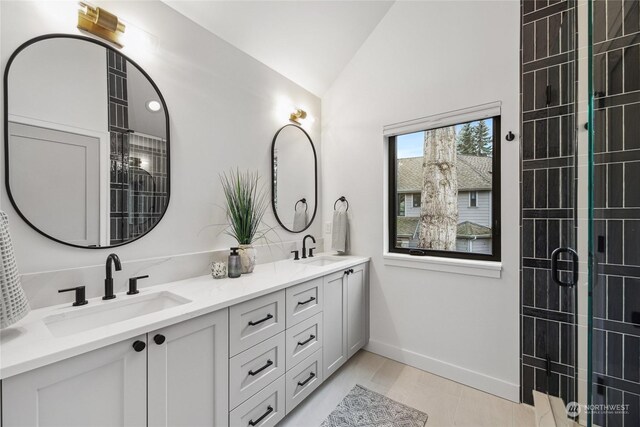 bathroom with tile patterned floors, vanity, lofted ceiling, and walk in shower