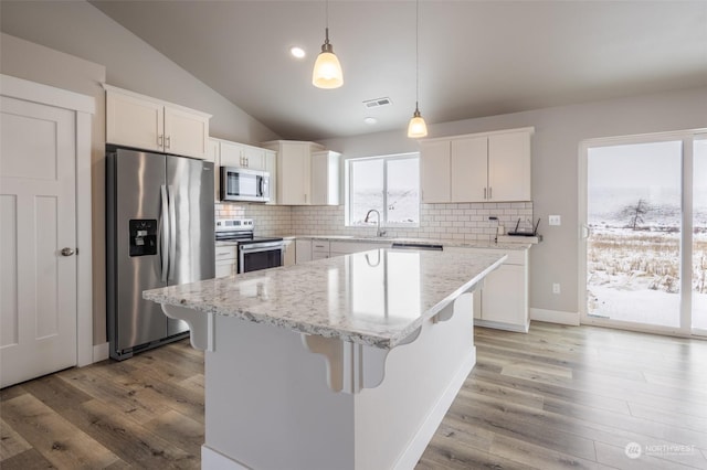 kitchen featuring white cabinetry, stainless steel appliances, and a center island