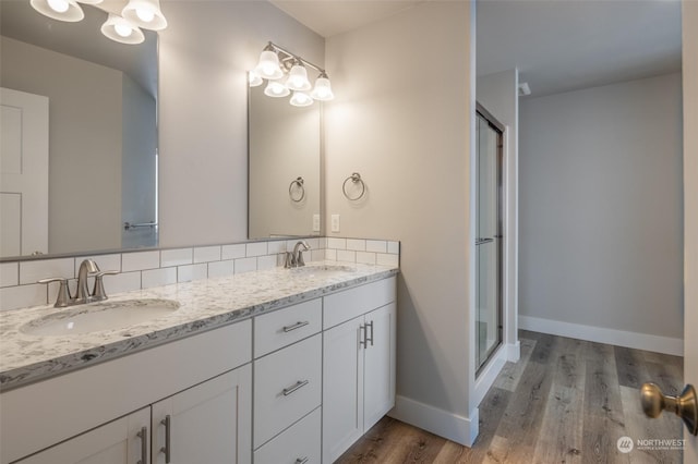 bathroom featuring vanity, backsplash, hardwood / wood-style flooring, and walk in shower