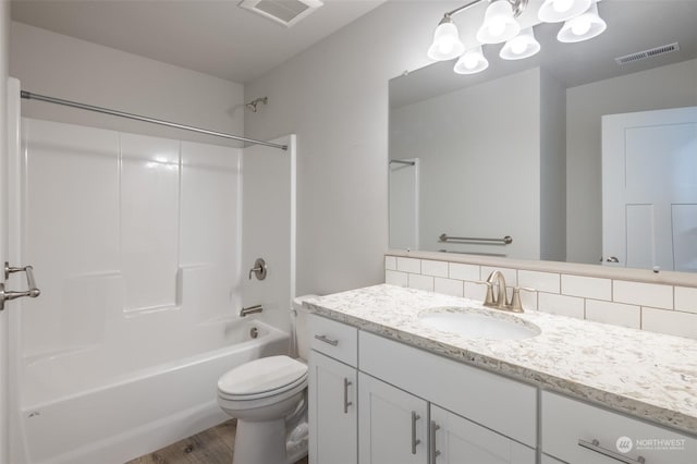 full bathroom featuring toilet, shower / washtub combination, vanity, hardwood / wood-style flooring, and decorative backsplash