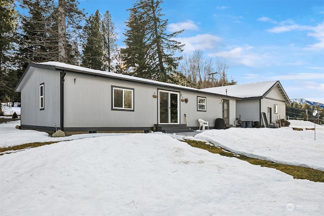 view of snow covered rear of property