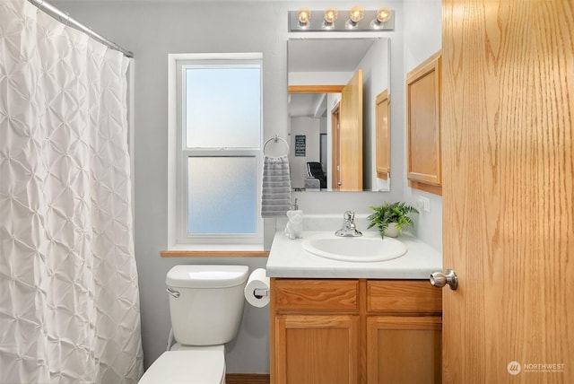 bathroom with toilet, walk in shower, and vanity